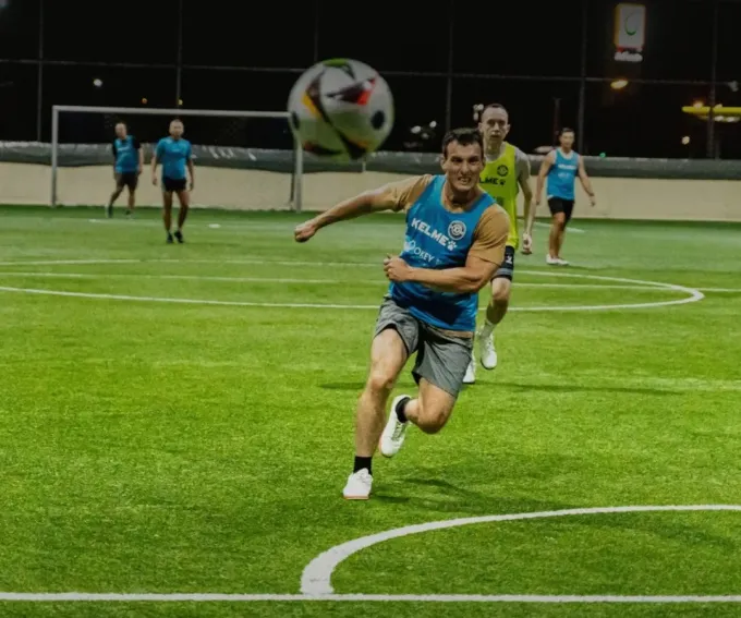 Players in action during an evening five-a-side football game